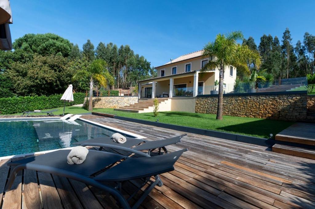 a house with a pool and a deck with a chair at Golden View in Vale de Tábuas