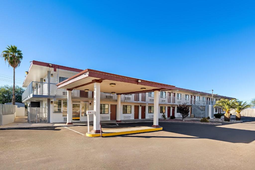 a large building with a fueling station in a parking lot at Red Roof Inn Tucson - Vail in Tucson