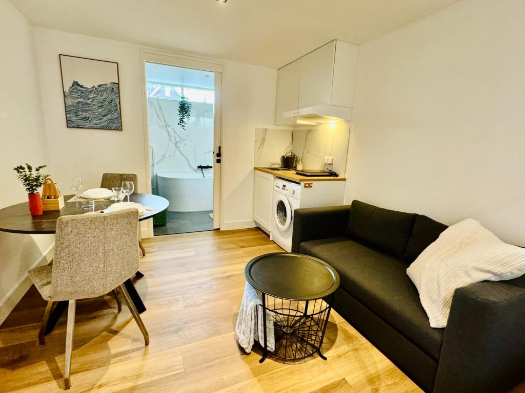 a living room with a couch and a table at Stylish private-entrance studio with bath and shower near Nijmegen Centre and Arnhem Zuid in Nijmegen