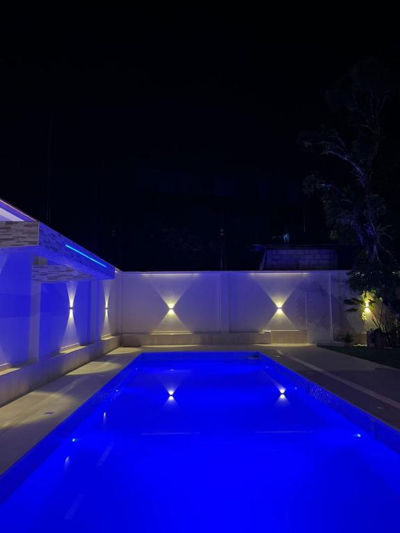 a swimming pool lit up at night with lights at Valle Hermoso in San Ramón