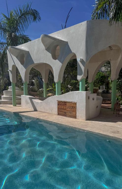 a pool with a pavilion next to a swimming pool at Calle Ouvert in Mérida