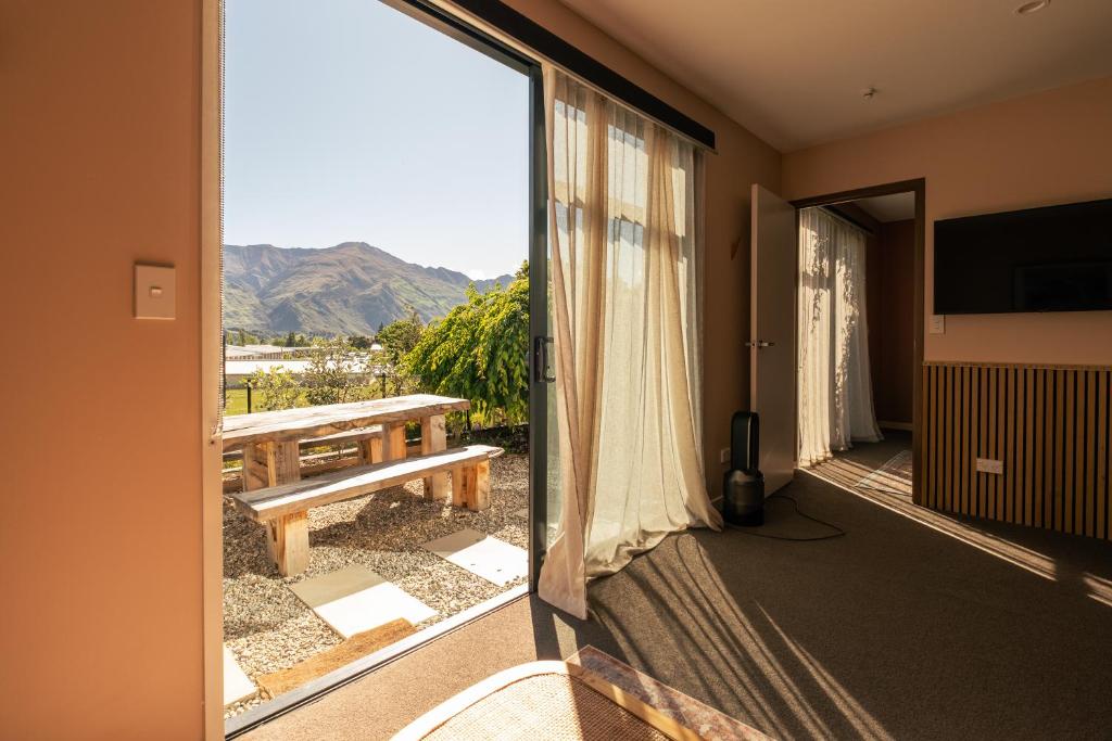 a room with a balcony with a view of the mountains at Studio C with all you need in Wanaka