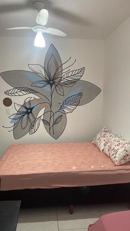 a bedroom with a flower mural on the wall at El Laai Roi in Iguaba Grande