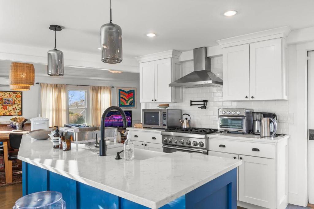 a kitchen with white cabinets and a blue island at West End Haven w/ Modern Kitchen + Private Yard in Provincetown