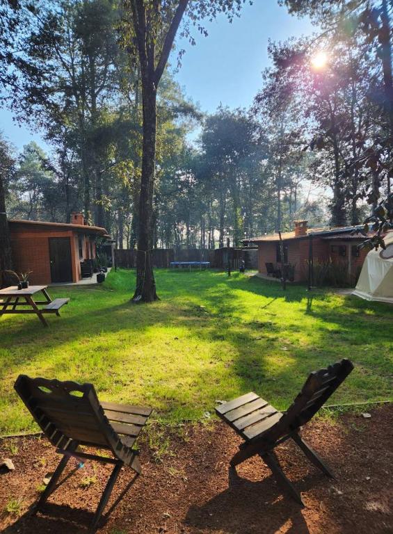 a picnic table and two chairs in a yard at Cabanas Madre Tierra Zacatlan in Cedro