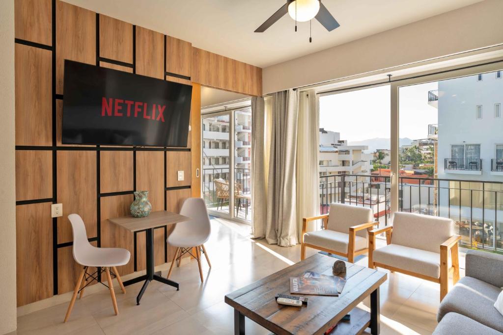 a living room with a television on a wall at Life Bucerias in Bucerías