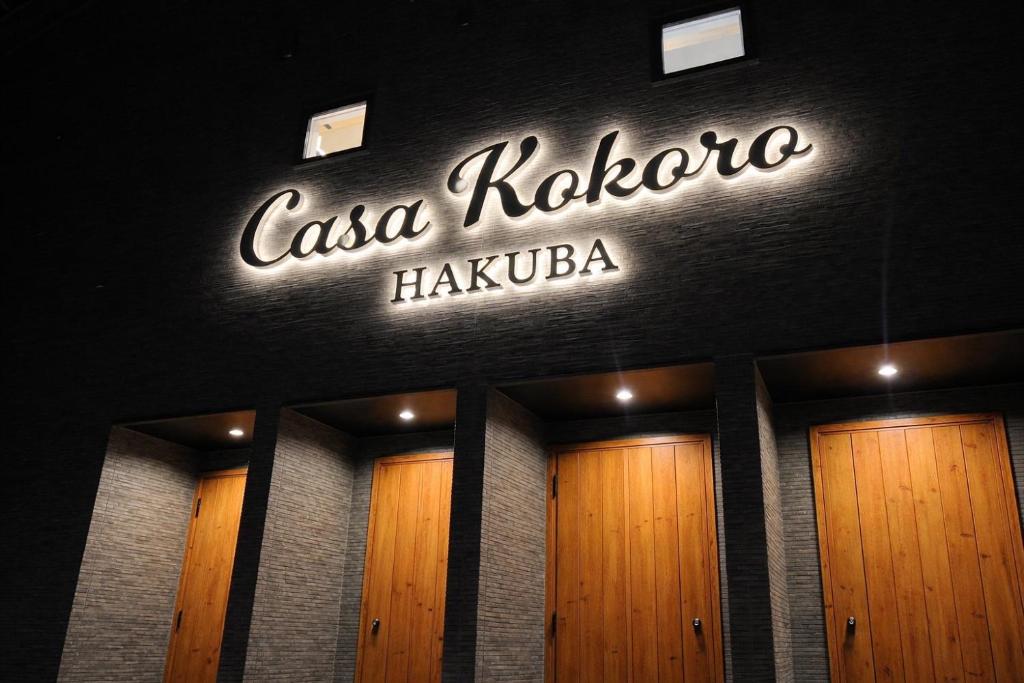 a sign on the front of a building with wooden doors at Casa Kokoro Hakuba in Hakuba