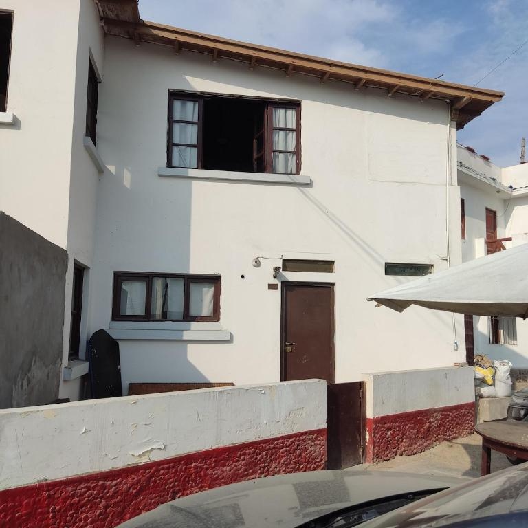 a white house with a door and a window at La Palmera Apartment in San Bartolo
