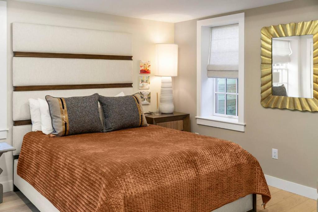 a bedroom with a bed and a window and a mirror at Modern Design - Walk to Galleries + Beach + Dining in Provincetown