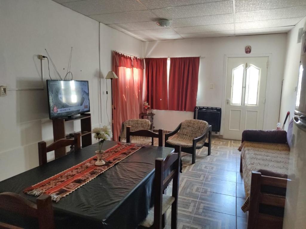 a living room with a table and chairs and a tv at Lo de Norma in Neuquén
