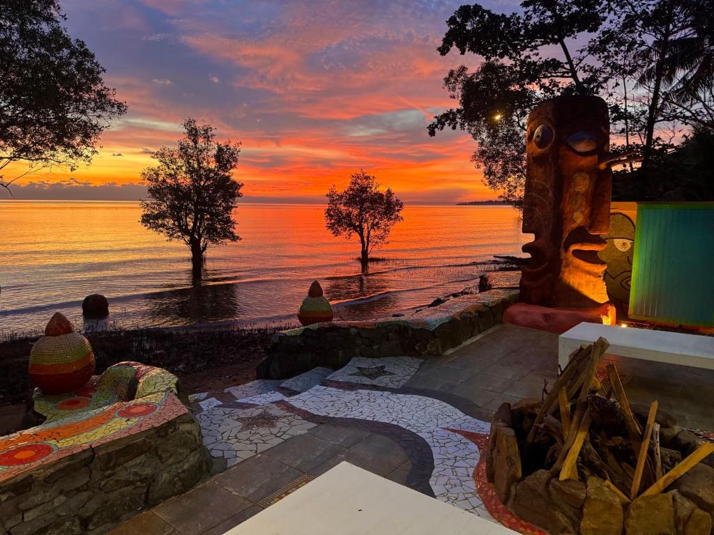 a sunset over the ocean with people sitting in front of a patio at Blessed Koh Chang in Ko Chang