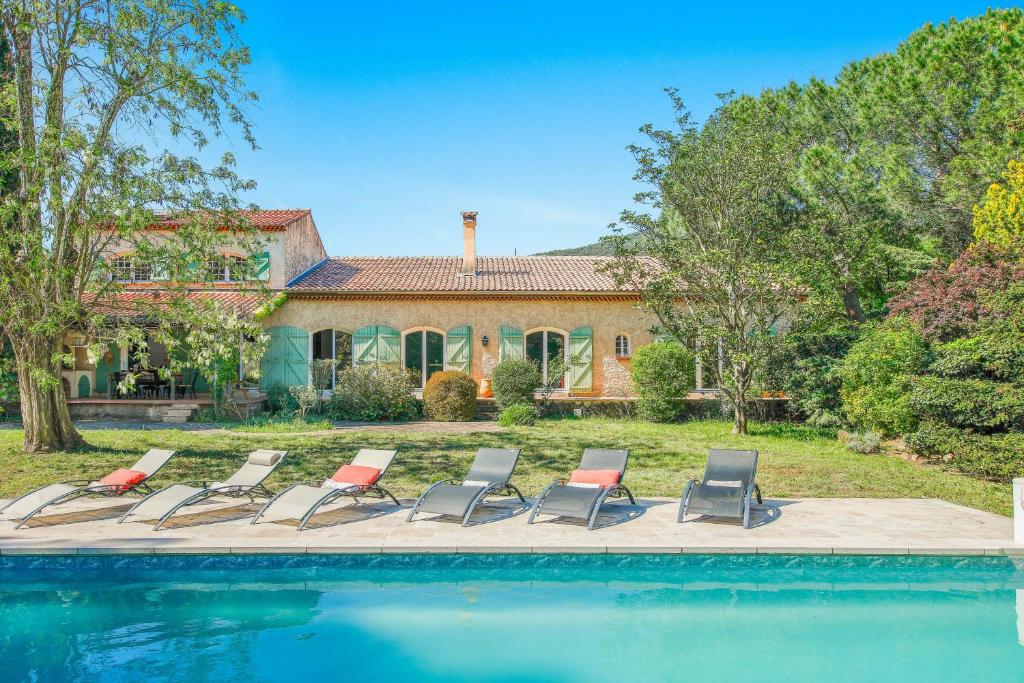 a group of chairs sitting next to a swimming pool at Provencal Villa With Pool In Collobrières in Contre