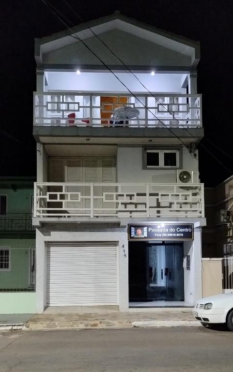 a white building with a balcony on top of it at Pousada do Centro in São Gabriel