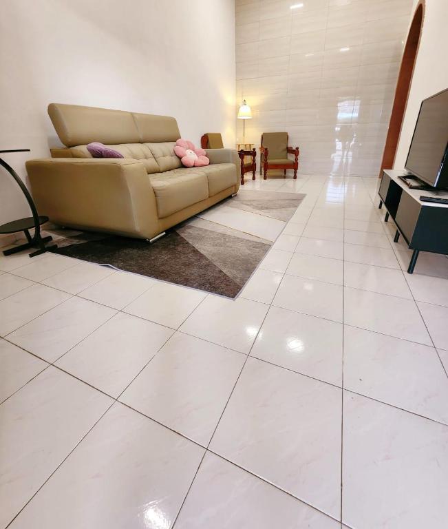 a living room with a couch and a television at Mersing 746homestay-9pax in Mersing
