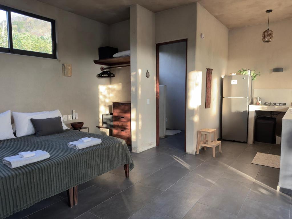 a living room with a bed and a refrigerator at Quiet Oceanside Casita Private Kitchen & Bath in Troncones