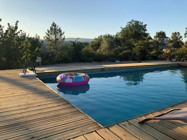 a swimming pool with a raft in the water at Hamlet de moment Ardeche com in Lablachère