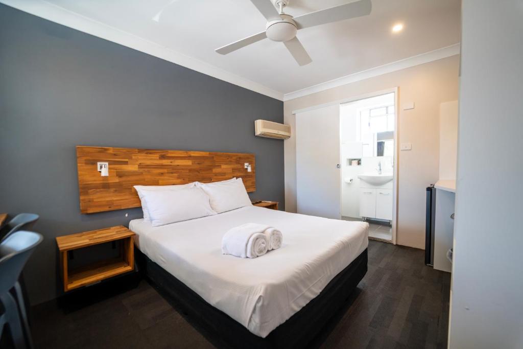 a bedroom with a bed and a ceiling fan at Nowra Motor Inn in Nowra