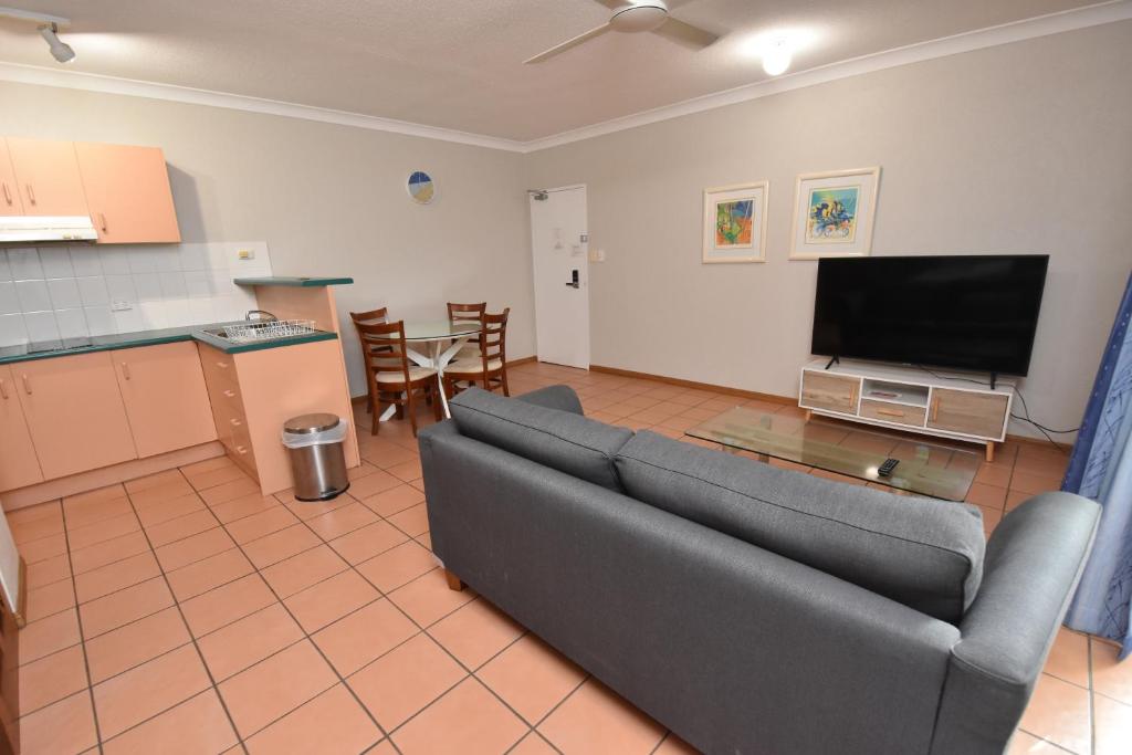a living room with a couch and a flat screen tv at Royal Palm Villas in Cairns