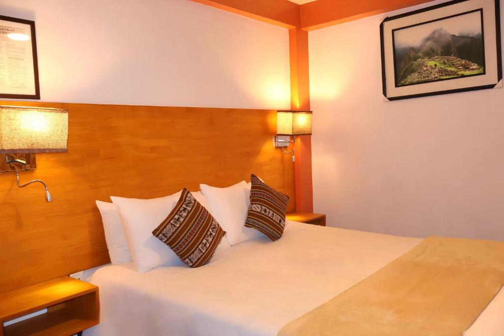 a hotel room with a bed with two pillows at Amakonkay Machupicchu in Machu Picchu