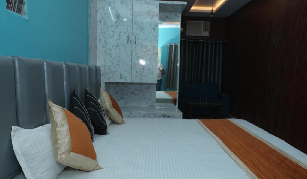a bedroom with a bed with pillows on it at Hotel Evergreen in Arāria