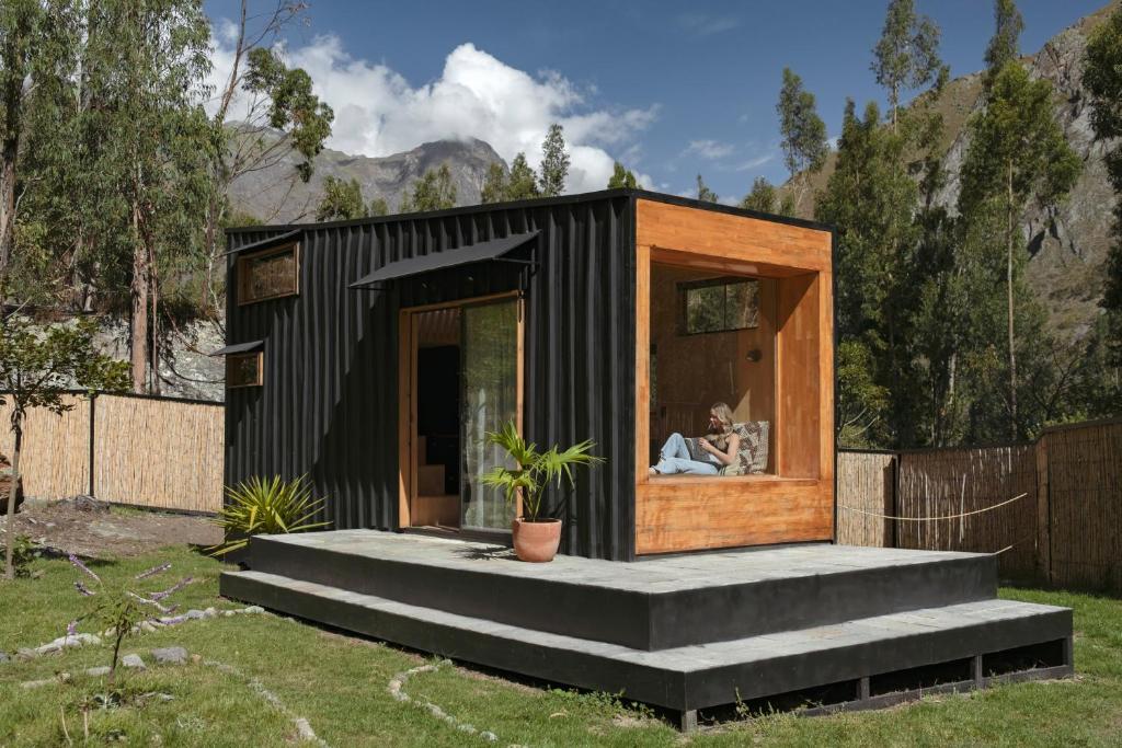a black tiny house with a large window at Earth Tones Tiny Homes & Suites in Ollantaytambo