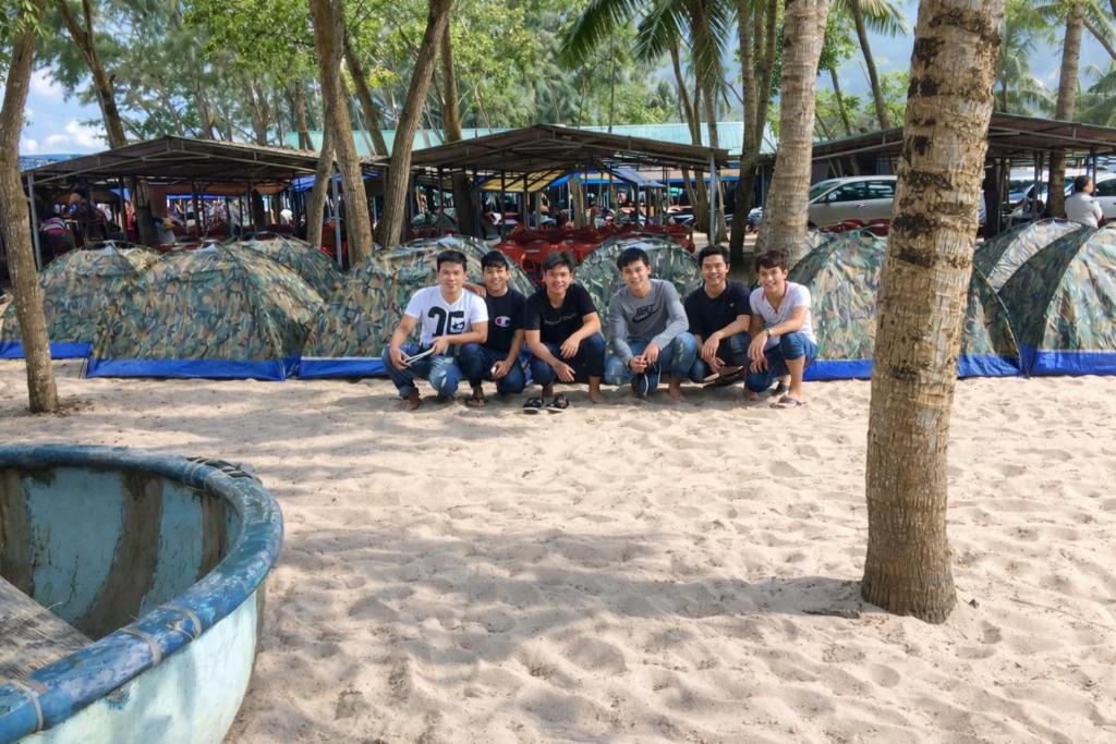 a group of people sitting in the sand at a water park at Vườn Dừa Cam Bình 1 in Lagi