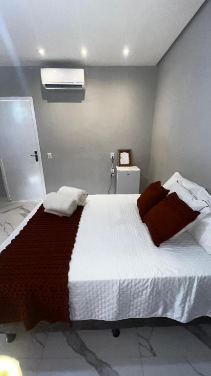 a bedroom with a large bed with two pillows on it at Studio no Centro da Cidade in Parauapebas