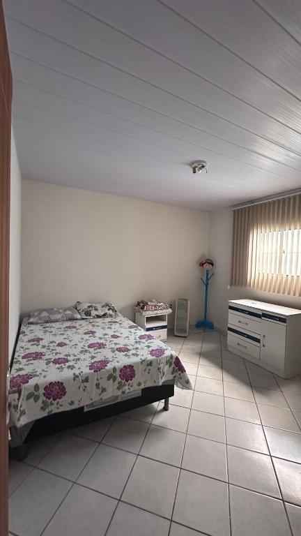 a bedroom with a bed and a desk in it at Casa espaçosa e arejada in Garanhuns