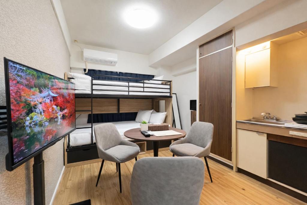 a small apartment with a bed and a table and chairs at サンシティ大濠公園 in Susakiuramachi