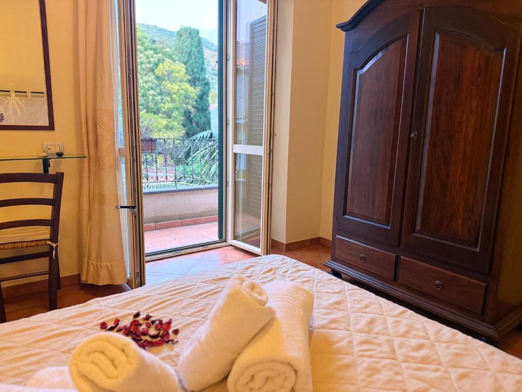 a bedroom with a bed with towels and a window at Noelia guesthouse in Bosa