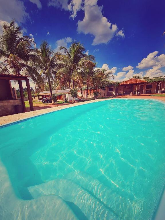 a large pool of blue water with palm trees at POUSADA POR DO SOL in Olímpia