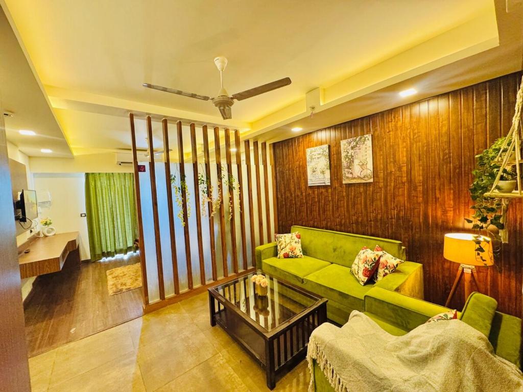 a living room with a green couch and a table at Studio in Dehradun in Dehradun