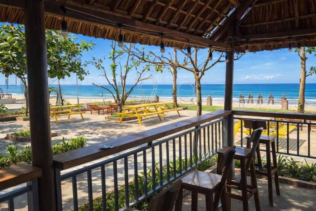 a view of the beach from a restaurant with tables and chairs at Newlife Homestay & Restaurant in Dong Hoi
