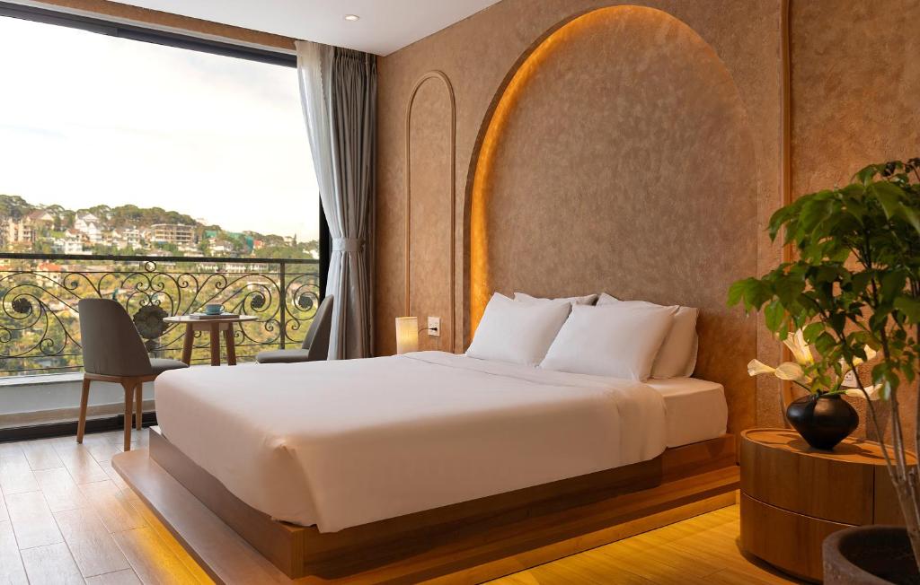 a hotel room with a bed and a balcony at Gold View Boutique Hotel Đà Lạt in Da Lat