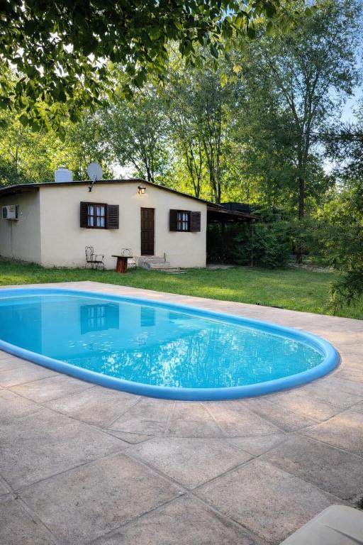 a large blue swimming pool in front of a house at El Bosque de Simba - Cabaña in La Estancia