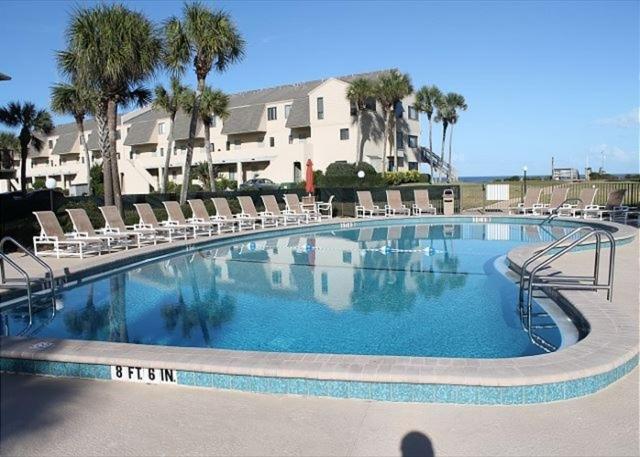 a large swimming pool with lounge chairs and a resort at Summerhouse 218 condo in St. Augustine