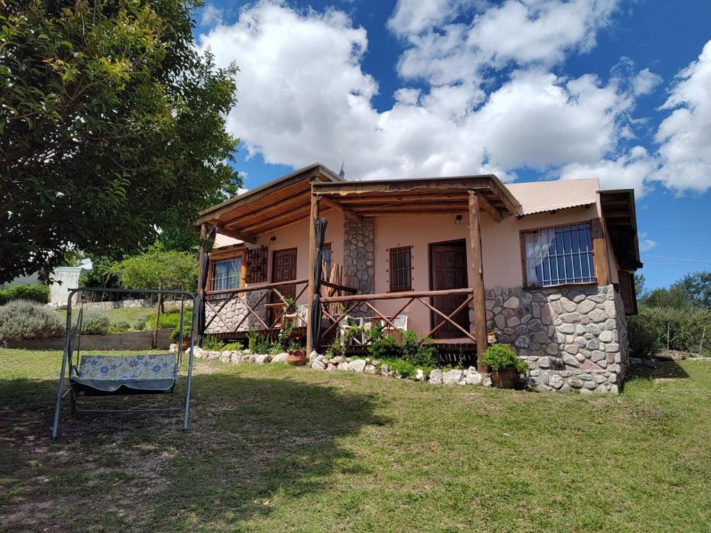 a house with a playground in front of it at Cabañas Mónika IV Sur in Huerta Grande