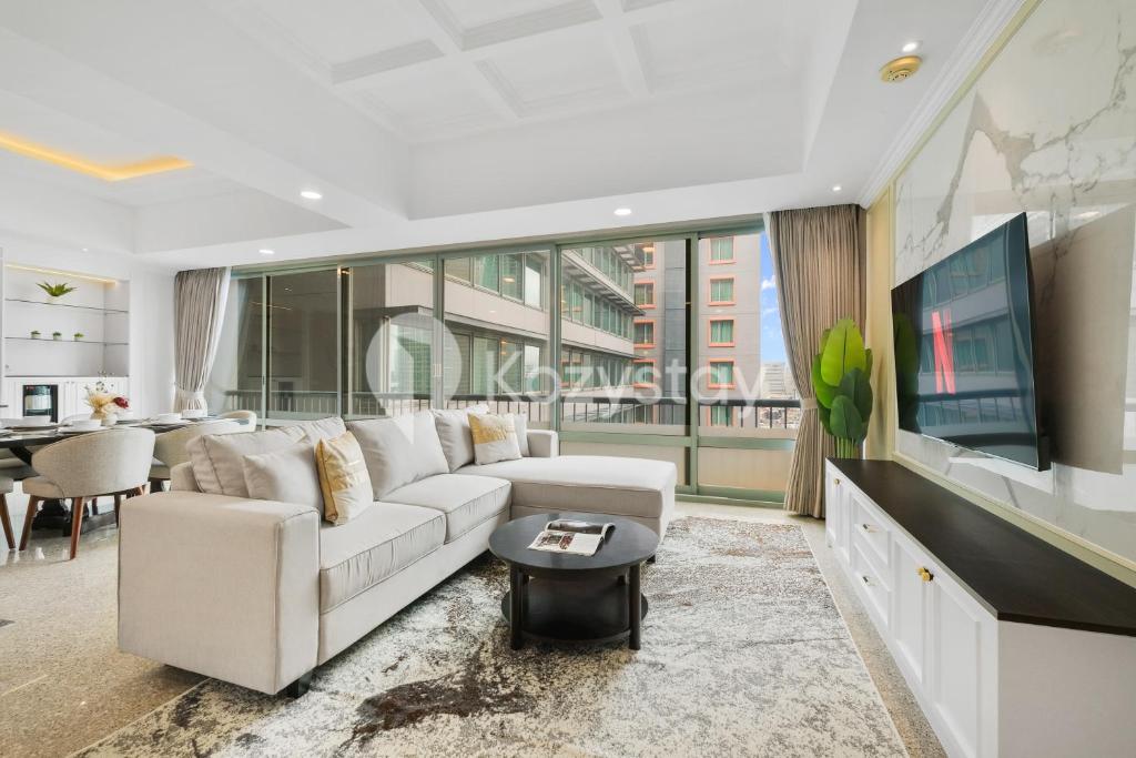 a living room with a white couch and a tv at Rosen by Kozystay - Thamrin in Jakarta