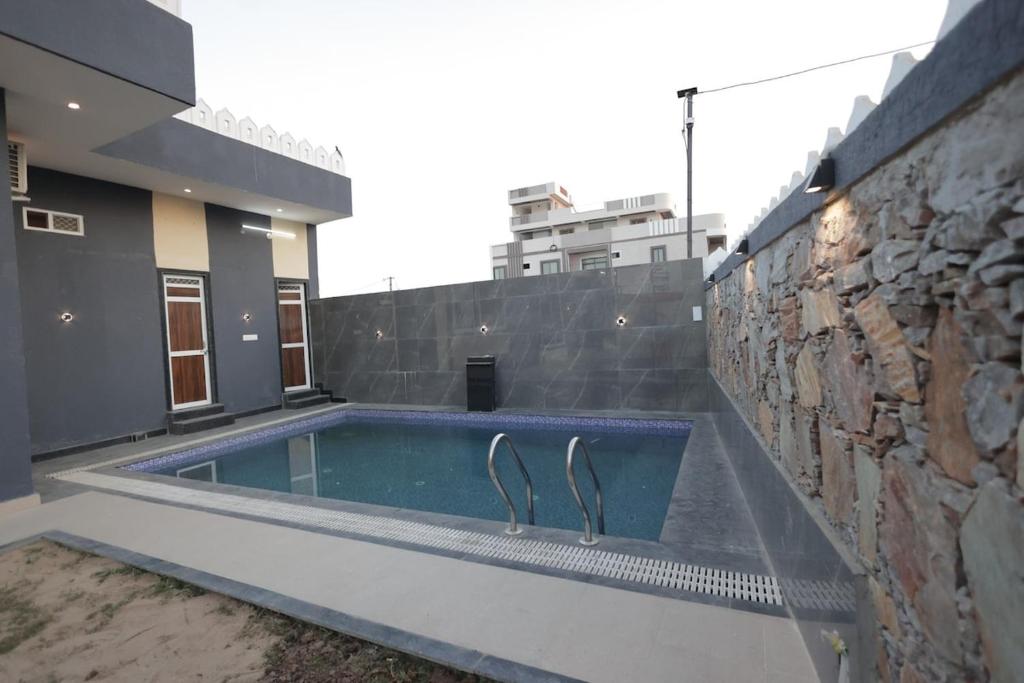a swimming pool in front of a building at villa Belmond with private pool in Udaipur