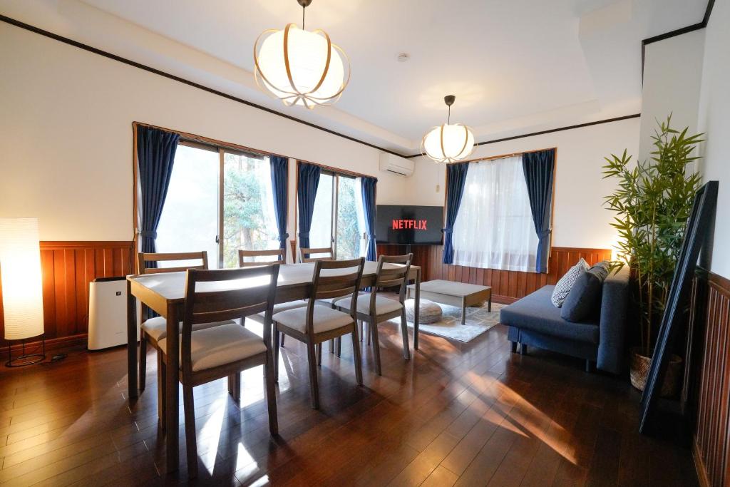 a living room with a table and chairs and a couch at Hideaway Hakone Sengokuhara in Sengokuhara