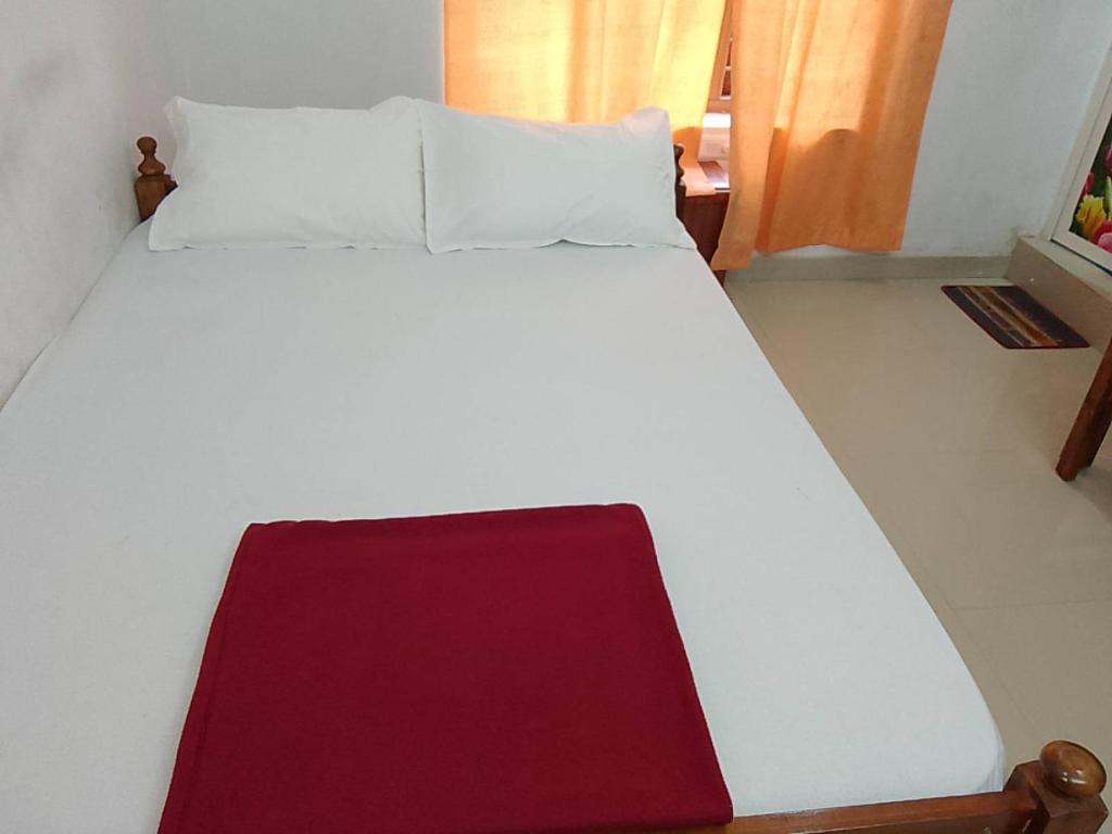 a large white bed with a red blanket on it at Somatheertham Resort in Kovalam