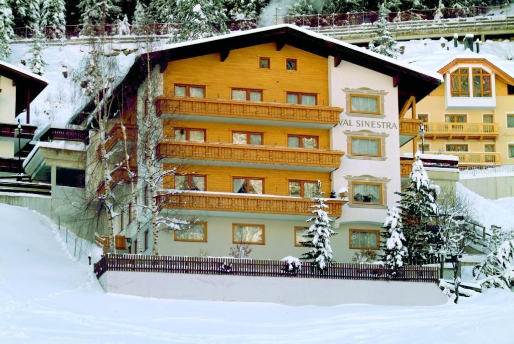 a large building with snow on the ground at Hotel Garni Val-Sinestra in Ischgl