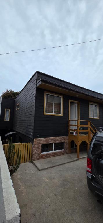 a black house with a car parked in front of it at Maitencillo Shelter in Puchuncaví