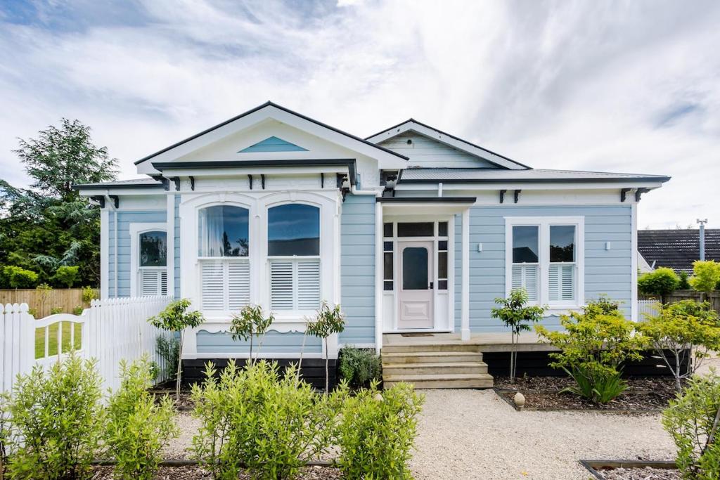 a blue house with a white fence at Britannia Villa in Greytown