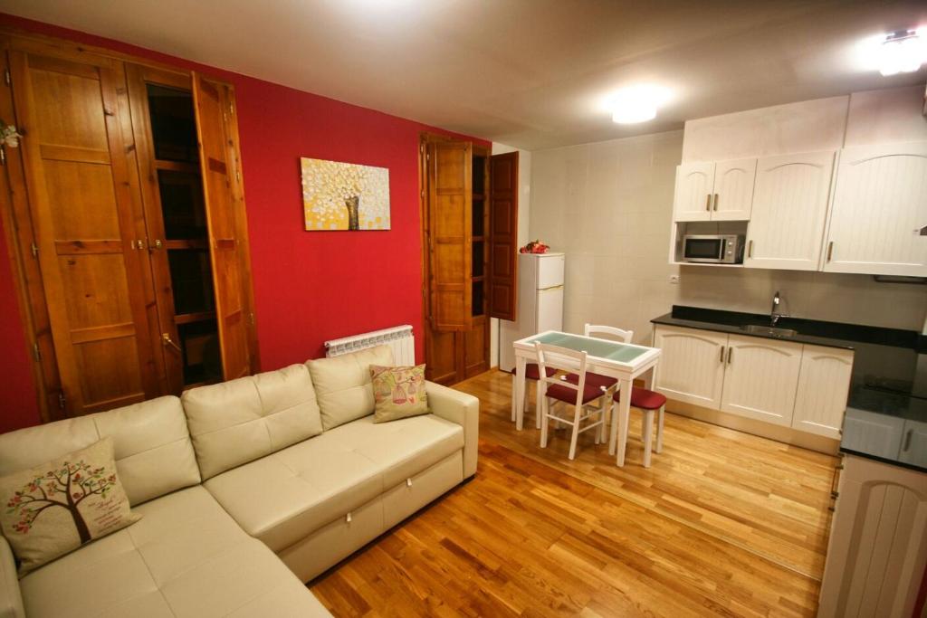 sala de estar con sofá blanco y cocina en El Mirador del Rioja, Zona Laurel, en Logroño