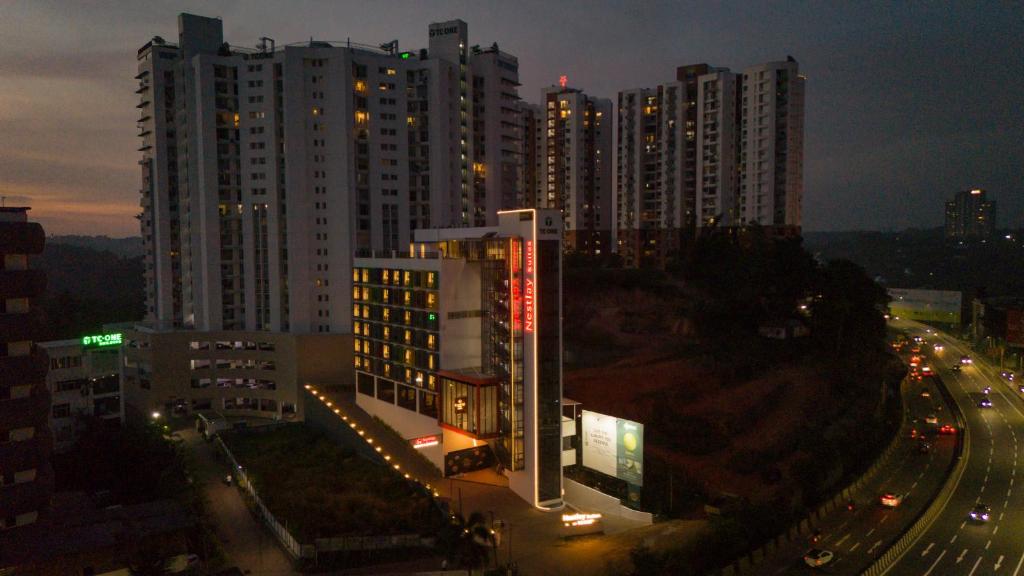 a night view of a city with tall buildings at Nestlay Suites by TC One in Kozhikode