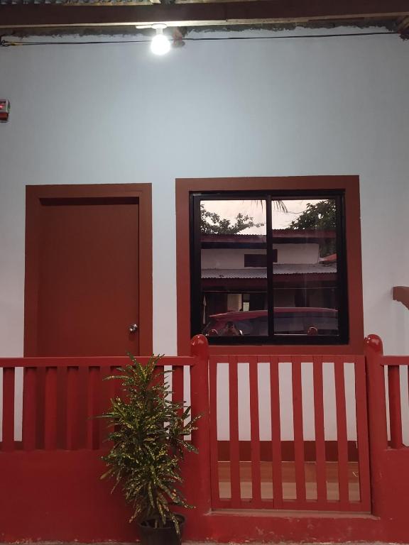 a house with a red fence and a window at Mangas Residents in El Nido