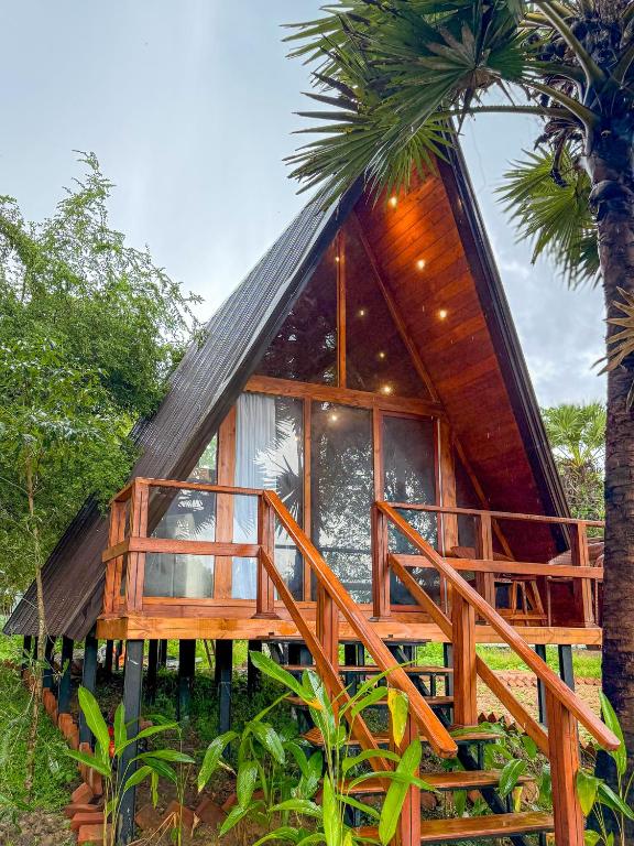 a cabin with a deck and a tree at Leopard Inn Wilpattu in Ilavankulam