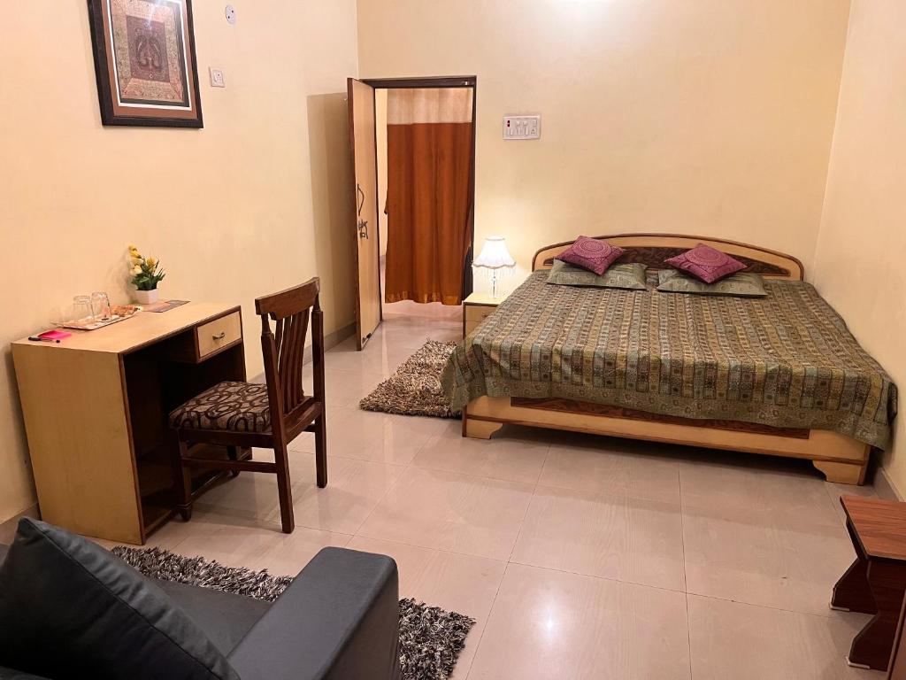 a bedroom with a bed and a desk and a chair at Sheetal Homestay in Varanasi