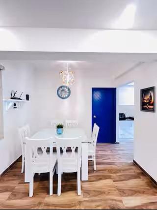 a white dining room with a white table and chairs at Feel Goa at Poolview 2BHK Luxury Apartment in Arpora